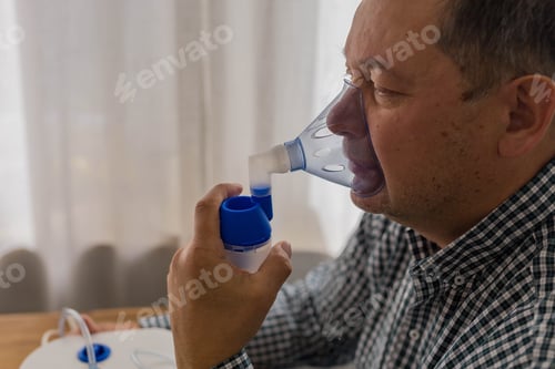 Preview: Man Uses Nebulizer Mask For Respiratory Treatment