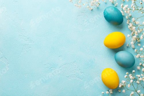 Preview: Colorful Easter eggs with flowers on blue background. Top view. Copy space.