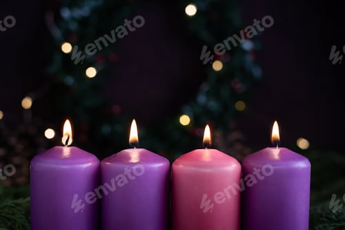 Preview: Close-up of four burning purple advent candles.