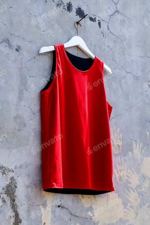 Preview: Stylish Red Tank Top Hanging Against Distressed Concrete Wall