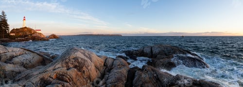 Preview: Panoramic view of a rocky ocean coast during a vibrant sunny sunset