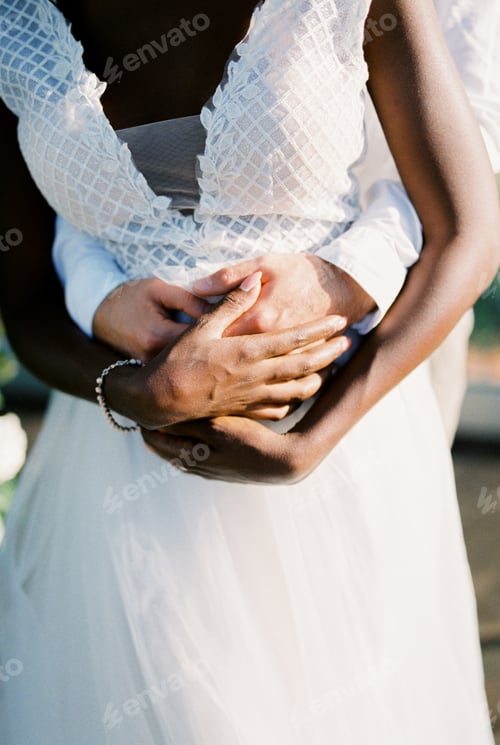 Preview: Groom hugs bride from behind. Close-up