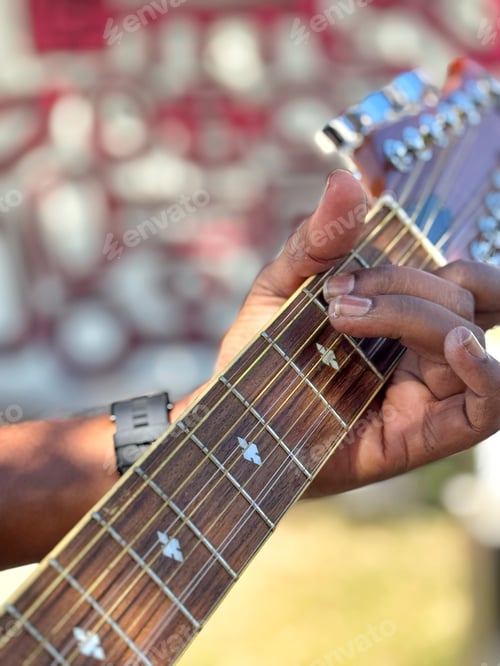 Preview: Closeup of an unrecognizable diverse musician playing acoustic guitar at an outdoor festival