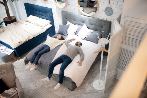Preview: Man and woman laying on bed furniture salon