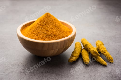 Preview: Organic Haldi or Turmeric powder spice pile in a bowl with whole, selective focus