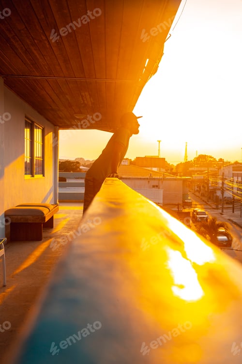 Preview: A young tourist looking through a terrace on the coast of Tela in a sunset. Honduras