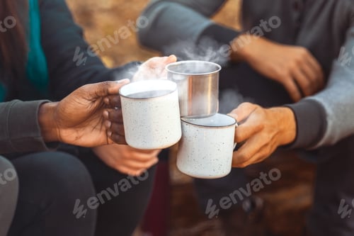 Preview: Hands of hikers cheering up with camping cups
