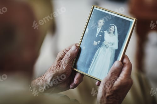Preview: Cropped shot of a senior man staring at a old wedding picture
