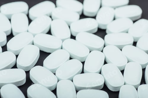 Preview: Medical white tablets or supplements for the treatment and health care on a black background