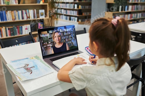 Preview: Girl Learning on Laptop in Library with Teacher