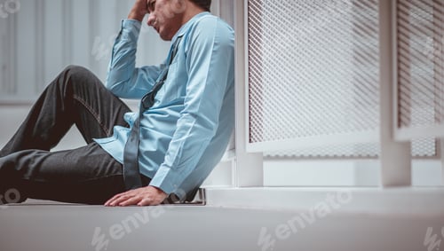 Preview: Businessman sitting on the floor after failure and layoff. Man unemployed from company sitting sad