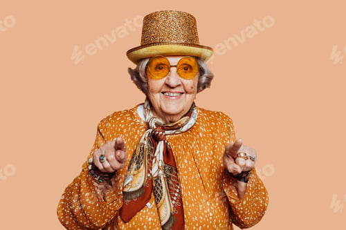 Preview: Cheerful housekeeper grandmother pointing two fingers at camera
