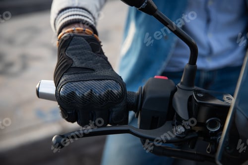 Preview: Close-up of an african biker's hand holding the handlebars of his motorcycle