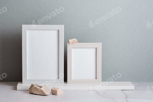 Preview: Eco friendly home decor two photo frames and stones on the table on a gray background. Pastel shades