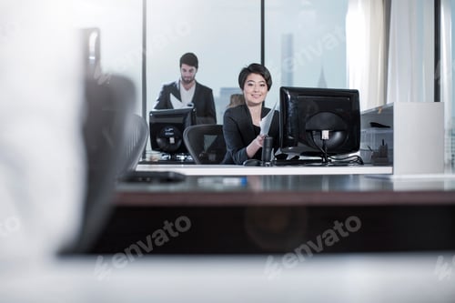 Preview: Smiling woman sitting at desk in city office
