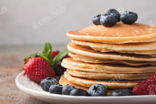 Preview: Delicious pancakes close up, with fresh blueberries on rusty background. Top view