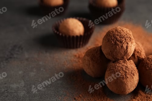 Preview: Tasty chocolate truffles powdered with cocoa on grey background, space for text
