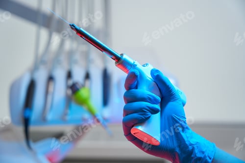 Preview: Hand of dentist holds device for three-dimensional obturation of canals