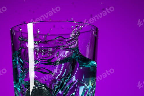 Preview: The water splashing in glass on lilac background