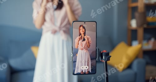 Preview: Asian girl blogger front of phone camera record video enjoy with dance content.