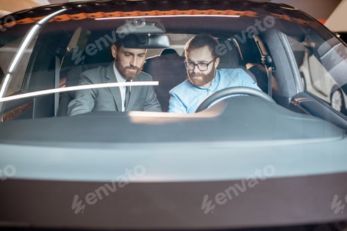 Preview: Sales manager with a client looking at the vehicle interior