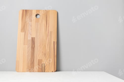 Preview: Wooden cutting board on table with linen tablecloth. Kitchen minimalist concept with copy space