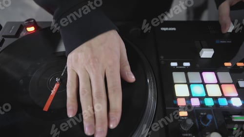 Preview: DJ spinning record at disco. Art. Close-up of DJ's hand on mixer. Glowing music panel at party