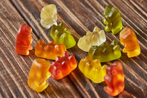 Preview: Multicolored bears gummy candy on wooden vintage background. Jelly candies of different colors