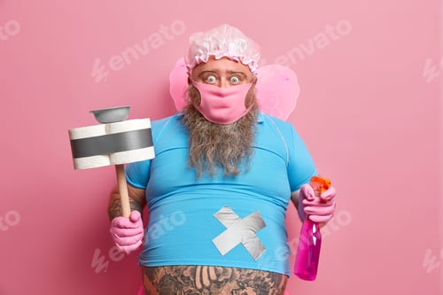 Preview: Shocked male housekeeper wears fairy wings does house chores holds spraying detergent and plunger wr