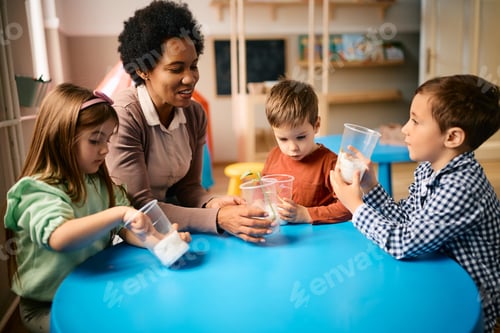 Preview: Group of preschool kids learning about planting seeds with their black female teacher.