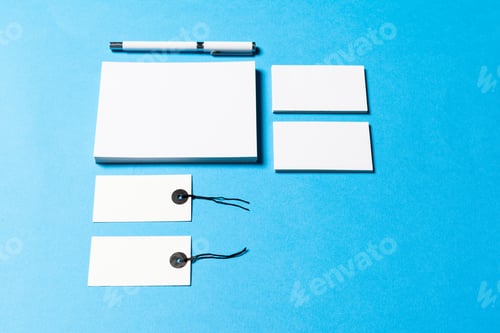 Preview: Collection of blank stationery items on a blue background with a pen at top