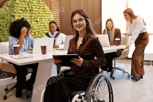 Preview: Confident disabled woman using tablet in inclusive modern office