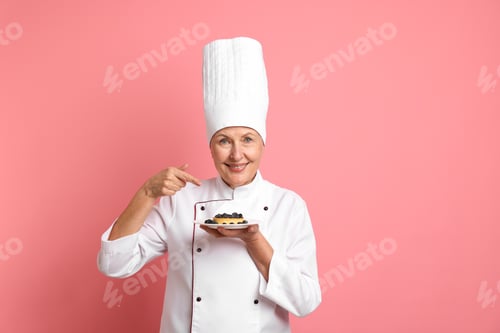 Preview: Professional pastry chef pointing at dessert on pink background