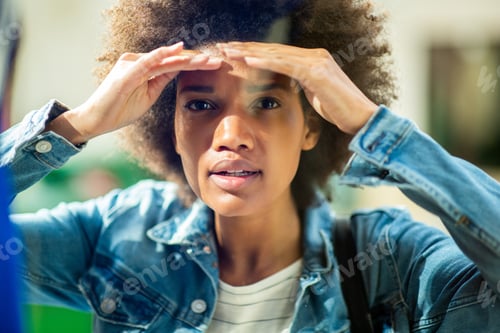 Preview: Close up young black woman peeking through glass window