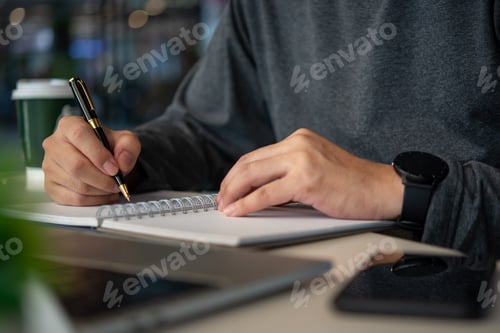 Preview: man hands with pen writing on notebook at table