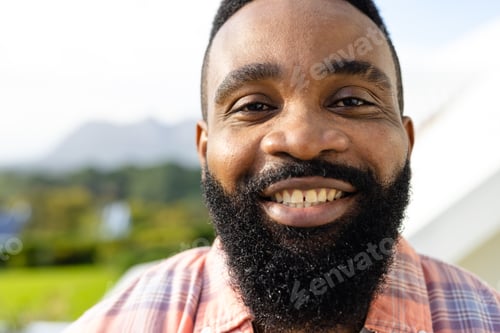Preview: Portrait of happy african american man on sunny terrace