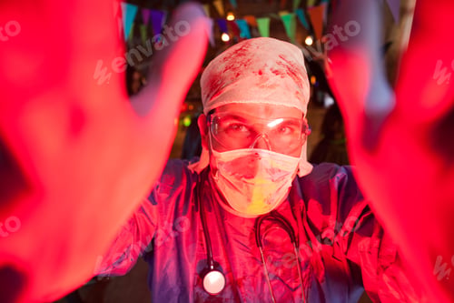 Preview: Cheerful young man dressed up like a creepy doctor for halloween