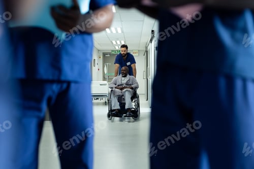 Preview: Diverse male healthcare worker pushing african american male patient in wheelchair in hospital