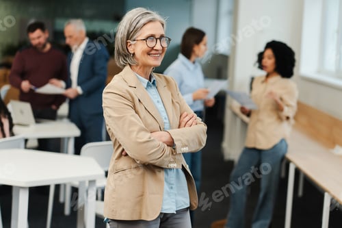Preview: Senior gray haired woman wearing stylish eyeglasses and formal wear with crossed arms looking away