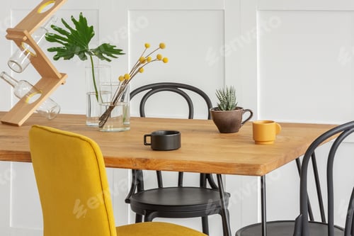 Preview: Stylish yellow chair at wooden dining table in trendy interior