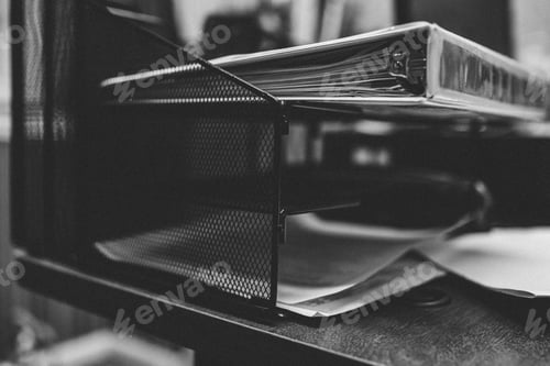 Preview: Grayscale closeup shot of folders and papers