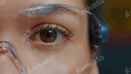 Preview: Woman with protective glasses showing one eye in front of camera
