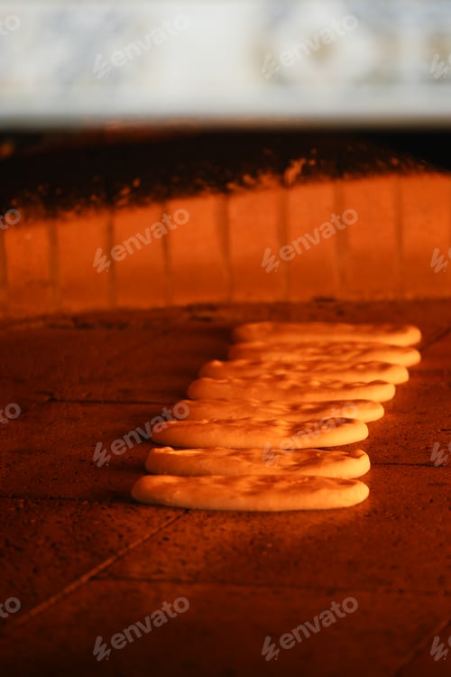 Preview: Freshly baked bread cooking in traditional oven at dusk
