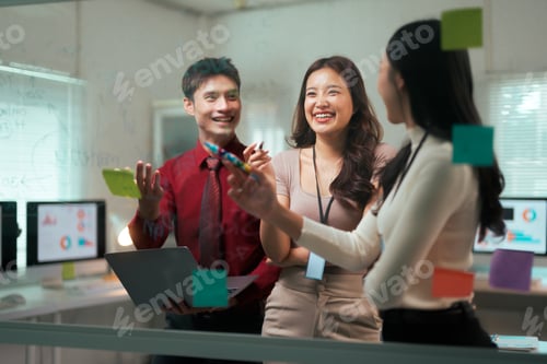 Preview: Asian business team brainstorming ideas presenting on glass board