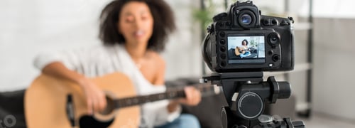 Preview: panoramic shot of digital camera with young african american girl in braces playing acoustic guitar