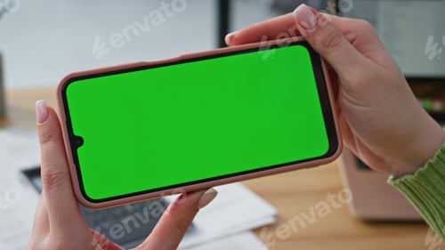 Preview: Entrepreneur video calling chroma key cellphone in modern light office closeup