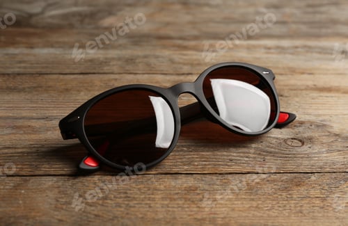 Preview: Stylish sunglasses on wooden background. Fashionable accessory