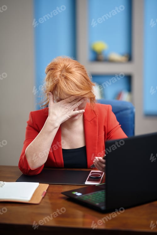 Preview: Overworked and stressed businesswoman working on laptop at the office