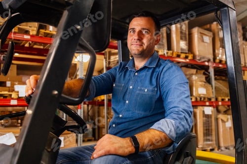 Preview: A young attractive forklift truck driver in a warehouse of goods