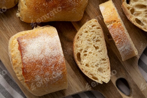 Preview: Homemade Sliced Ciabatta Bread on a wooden board, top view.